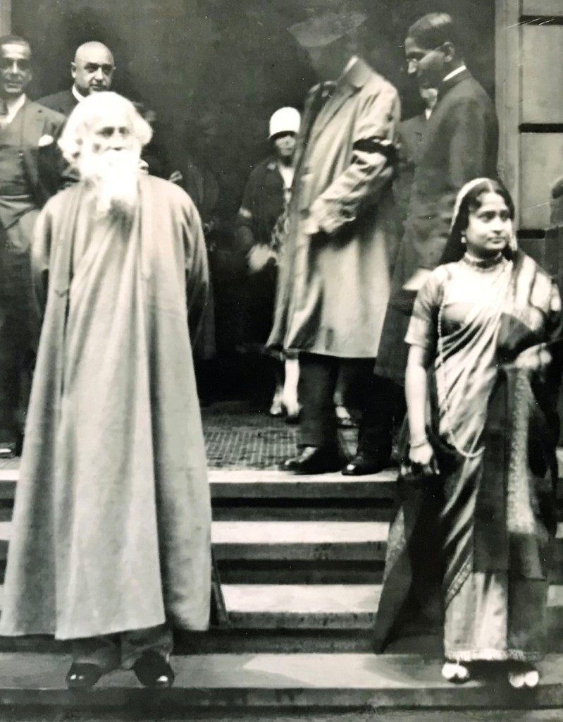 Rabindranath Tagore (left) during his visit to Hamburg, 1926, standing on stone steps with companions.